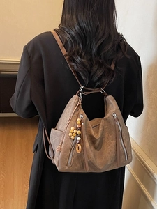 Vintage brown leather backpack for women, retro shoulder bag with beaded charm detail
