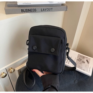 Dettaglio della borsa a tracolla quadrata in nylon nero con tasca con fibbia