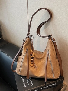 Retro brown oversized tote bag in matte finish on leather sofa with vintage wooden beads
