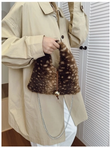 Détail d'un sac en peluche léopard avec bandoulière chaîne argent et fermoir boule dorée