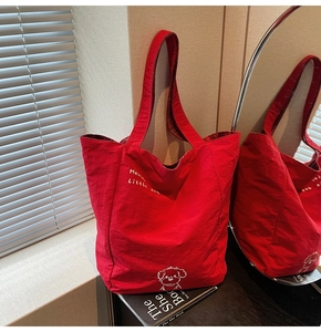 Close-up of red canvas tote bag featuring a cute white dog print and Hello Little Dog text