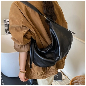 Detail view of a large black faux leather hobo shoulder bag with a soft textured finish