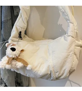 Detail of off-white quilted puffer cloud bag with cute puppy plush charm accessory