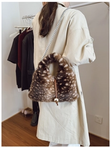 Vue détaillée du sac en fausse fourrure à motif cerf et poignée en métal sur manteau