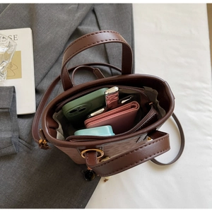 Interior view of brown bucket bag showing multi-compartments for phone and wallet