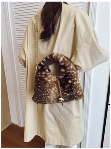 Détail d'un sac bandoulière en peluche à motif cerf avec fermoir doré et bandoulière chaîne