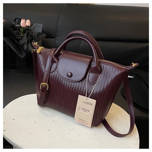 Dettaglio della trama intrecciata e pelle bordeaux della borsa con finiture dorate