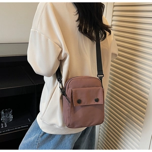 Vista posteriore di una borsa a tracolla in nylon rosa antico con ampia tracolla