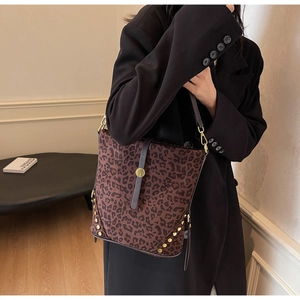 Detail of leopard print bucket bag featuring gold rivets and slim leather shoulder strap