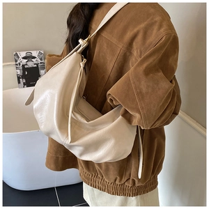 On-body shot of a large off-white hobo bag with soft leather texture and gold hardware
