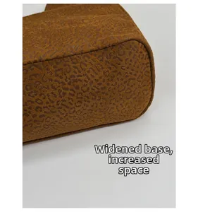 Gros plan détaillé du sac cabas léopard avec une base large renforcée pour le volume