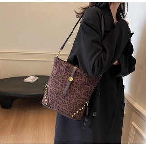 Close-up of leopard print bucket bag with gold rivets and leather strap detailing