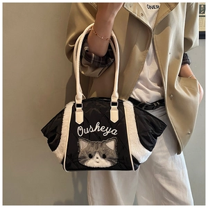Dettaglio borsa tote trapuntata nera con pannelli in ecopelliccia bianca e ricamo gatto