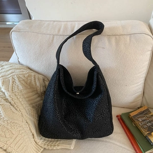 Détail de la texture léopard noire sur le grand sac hobo en cuir synthétique souple