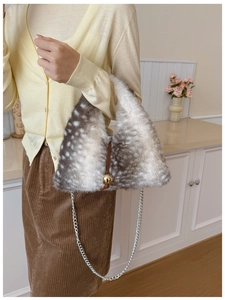 Détail du sac à main en fausse fourrure à imprimé cerf avec sphère dorée et chaîne