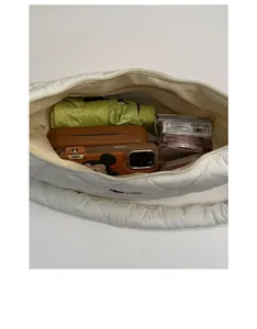 Top view of the spacious inner compartment of the white quilted puffy dumpling crossbody bag