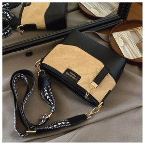 Detail of quilted leather bucket bag with geometric strap and gold metal chain hardware