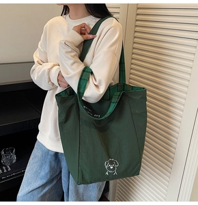 Detail of green canvas tote bag with cute dog print and green plaid inner lining