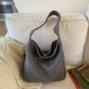 Gros plan d'un grand sac à bandoulière léopard gris foncé en daim avec fermoir argenté