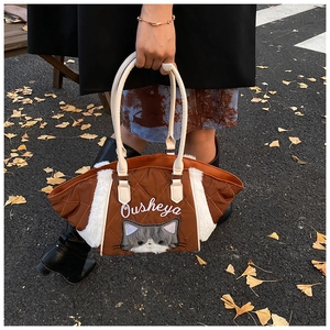 Dettaglio di una borsa tote marrone trapuntata con ricamo a gatto su foglie di ginkgo oro