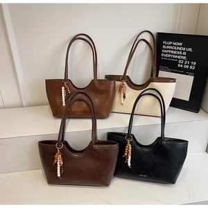 Disposition détaillée de quatre sacs cabas tissés en marron, caramel, noir et beige clair