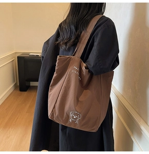 Close-up of brown canvas tote bag featuring a cute white dog print and cursive text