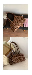 Detail of leopard print baguette bag with brown leather handles in cozy autumn home setting