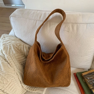 Gros plan du sac cabas à imprimé léopard posé sur un canapé avec couverture en maille