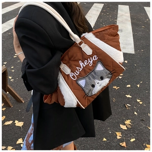 Dettaglio della borsa tote trapuntata marrone con bordo in peluche bianco e ricamo gatto