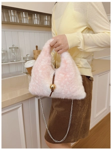 Détail du sac bandoulière en peluche rose et blanc avec breloque dorée et chaîne fine