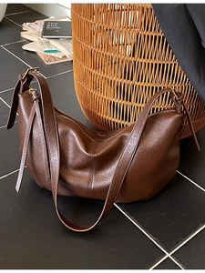 Deep brown matte leather half-moon hobo bag with adjustable strap and tassel detail