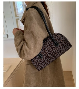 Close-up of vintage leopard print Boston bag with black faux leather handle and fine stitching