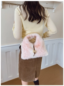 Détail du sac bandoulière en peluche rose et blanc avec chaîne et boucle dorée