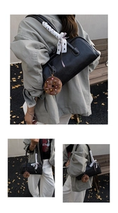 Detail view of black baguette bag with white stitching and decorative polka dot scarf