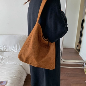Détail d'un grand sac cabas à imprimé léopard avec large bandoulière dans une chambre
