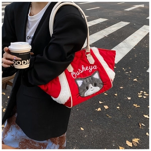 Dettaglio della borsa tote trapuntata rossa con bordo in peluche bianco e ricamo gatto