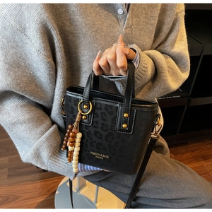 Detail of leopard print bucket bag with wooden bead tassel and fashion lettering