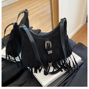 Dettaglio borsa a sella in pelle scamosciata nera con fibbia e lunghe frange in pelle