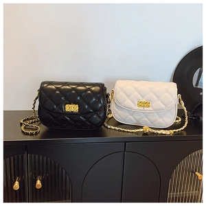 Detail of quilted chain crossbody bags in black and white with gold hardware