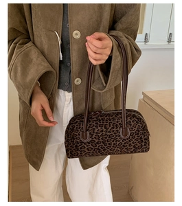 Close-up of retro leopard print baguette bag with brown leather strap on model
