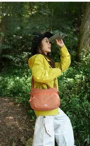 Detail of orange plaid crossbody bag with adjustable strap and light nylon fabric