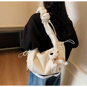 Detail of cream pleated cloud bag with soft nylon texture and cute puppy charm