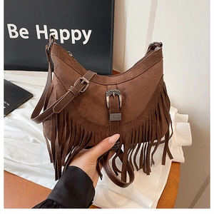 Dettaglio della borsa hobo marrone con frange, fibbia in metallo e finitura scamosciata