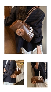 Detail of vintage brown leather handbag with plaid scarf and plush donut keychain charm