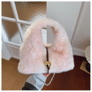 Détail du sac en fausse fourrure rose et blanc avec breloque dorée et chaîne argentée