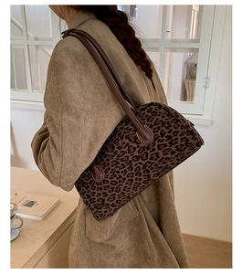 Detailed side view of a vintage leopard print baguette bag with brown leather shoulder straps