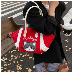 Dettaglio della borsa shopper trapuntata rossa con ricamo a gatto e bordi in finta pelliccia