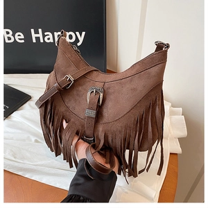 Dettaglio borsa a sella marrone opaca con nappe e fibbia in metallo inciso vintage