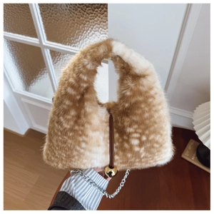 Détail du sac en peluche à motif cerf avec poignée en cuir et breloque boule dorée