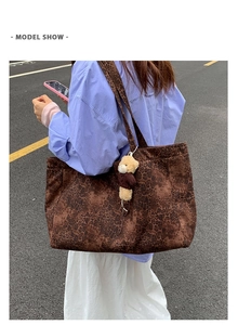 Large leopard print tote bag with plush bear charm shown on model in street setting